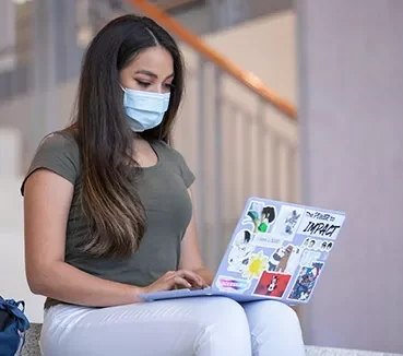 student typing on laptop