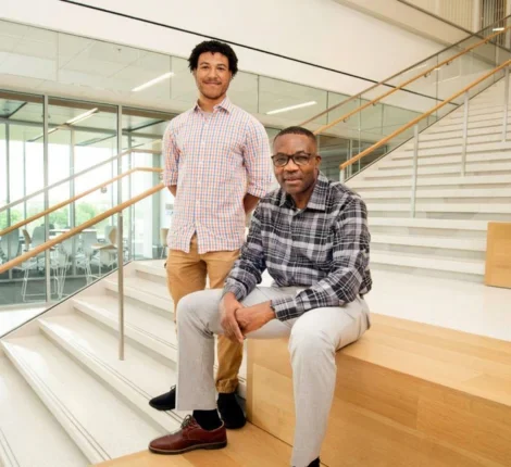 Two men sitting and standing on the stairway