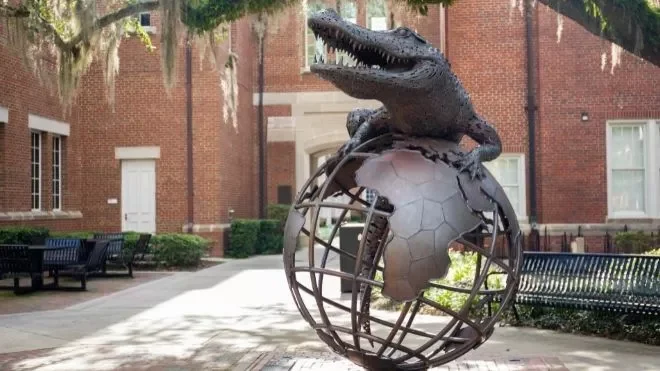 Global Impact - Slide Media statue of gator on globe